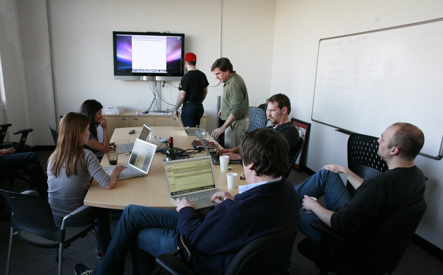 Colleagues working together with laptops in a professional setting