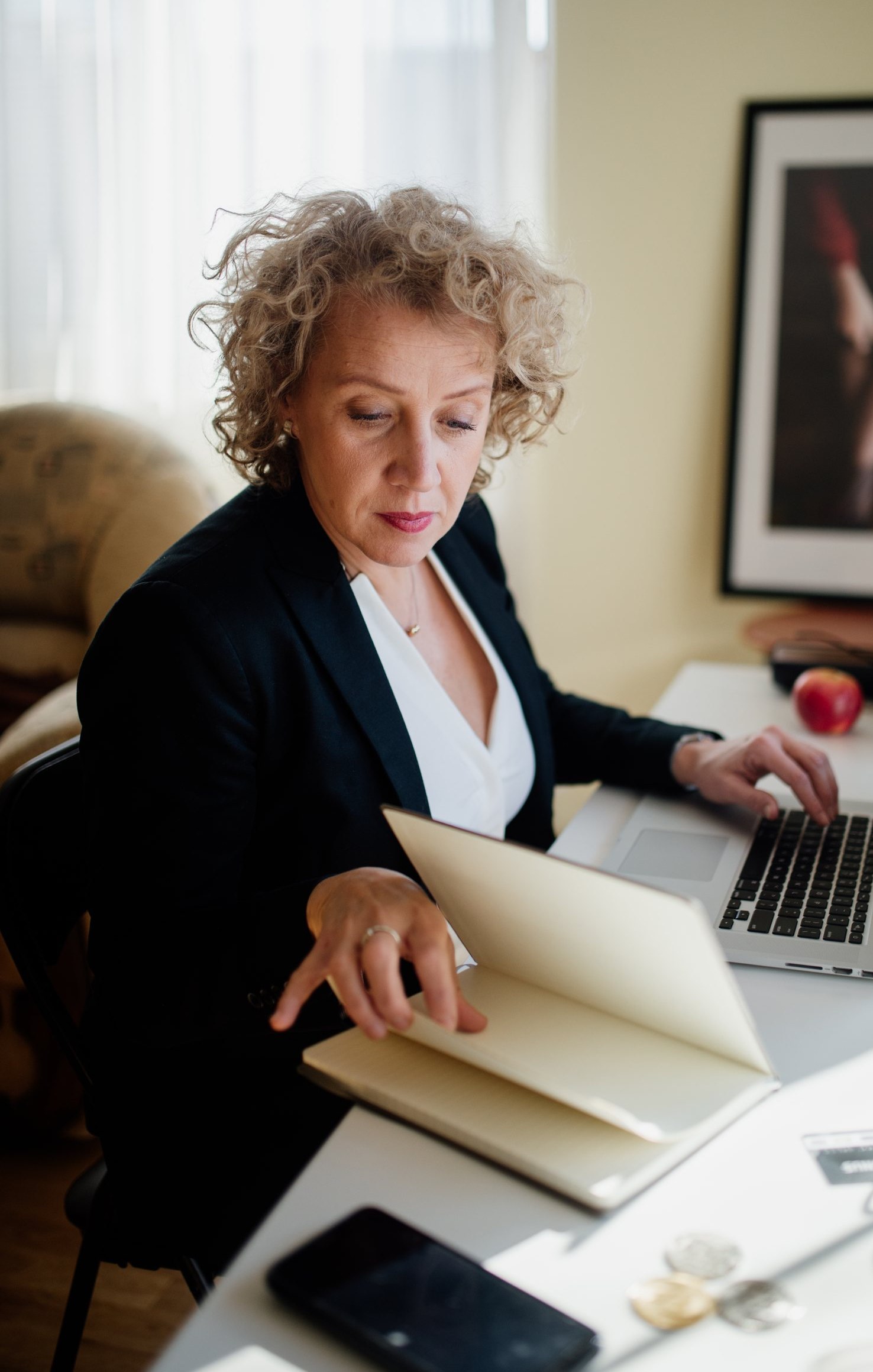 Professional reviewing work materials beside a laptop